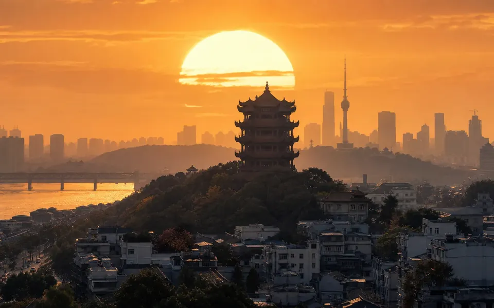 巨大夕阳映照下的武汉黄鹤楼与城市天际线